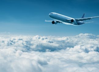 Spain Indicators Settlement With Korean Air to Promote Spanish Locations Airplane flies above clouds air travel