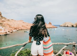 The very best time to cruise the Mediterranean woman looks out on ocean in Cala Morell Minorca Spain Carol Yepes